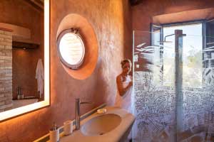 The <i>pietra serena</i> carved stone sink and Guido Giordano’s shower sculptured glass